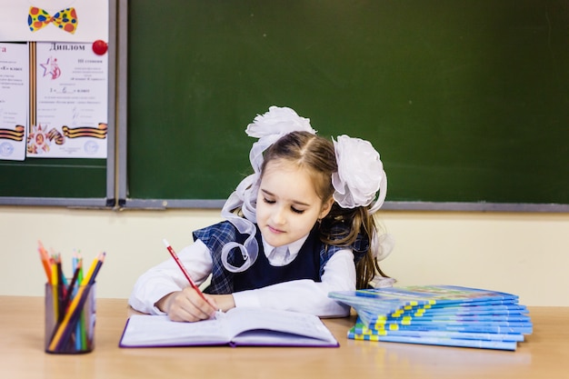 Menina colegial e escola. A garota usa um uniforme escolar na escola. Treinamento