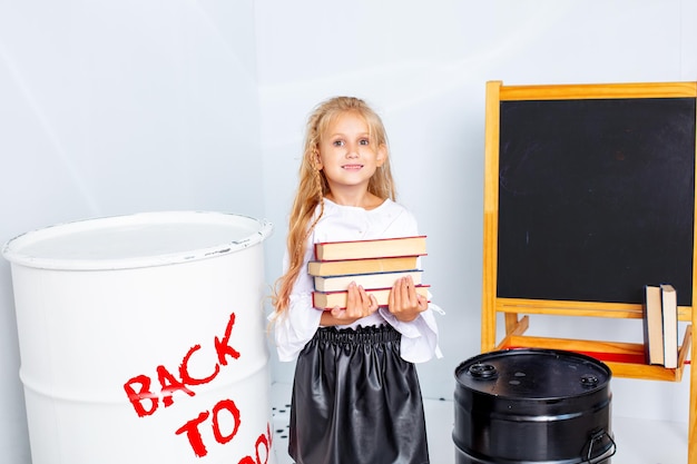 Menina colegial feliz e linda em um fundo branco, de volta às aulas