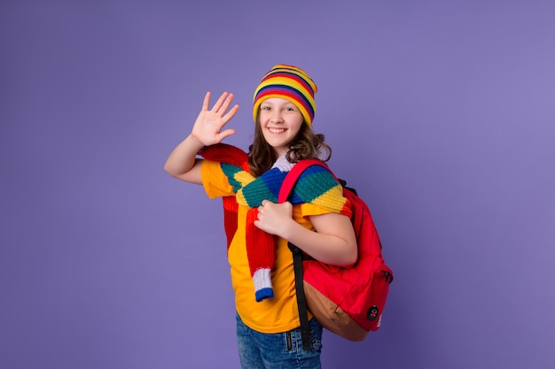 Menina colegial sorri com uma mochila no ombro