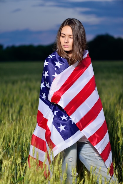 Menina com a bandeira americana nos ombros