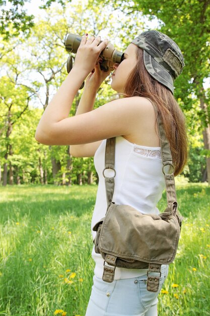 Menina com a bolsa olhando para o binóculo