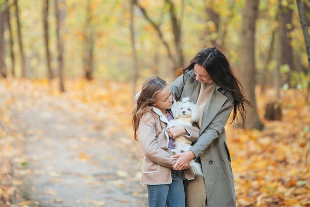 Menina com a mãe ao ar livre no parque no dia de outono