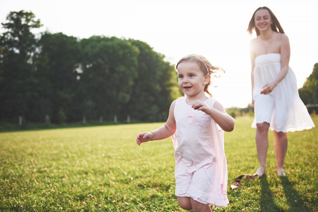 Menina com a mãe em dia ensolarado de verão.