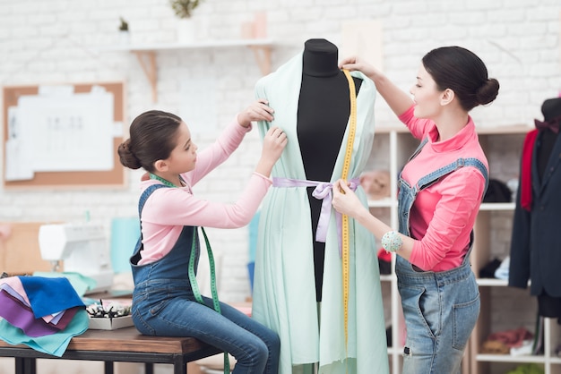 Menina com a mãe na oficina de costura.