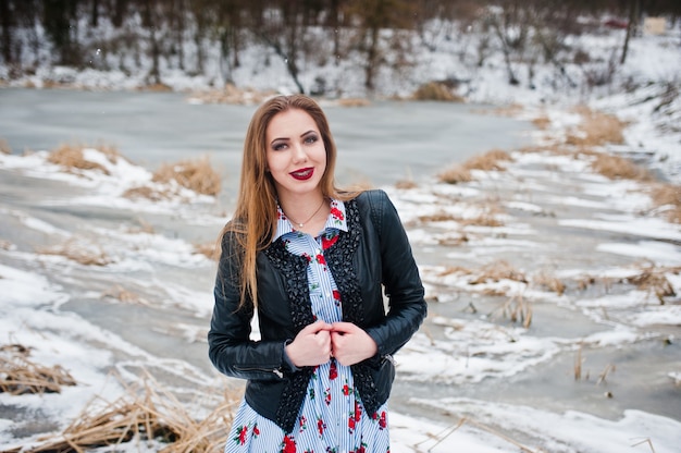 Menina com aparelho no dia de inverno contra lago congelado.