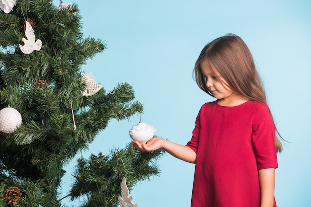 Menina com árvore de natal em fundo azul