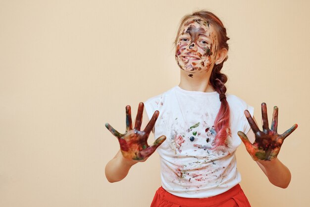 Menina com as palmas das mãos em tintas