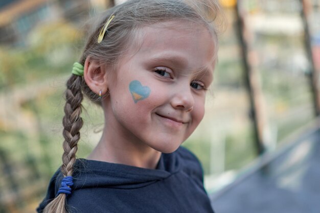 Foto menina com bandeira da ucrânia pintada de amarelo e azul pare a guerra e o poder do patriotismo da ucrânia