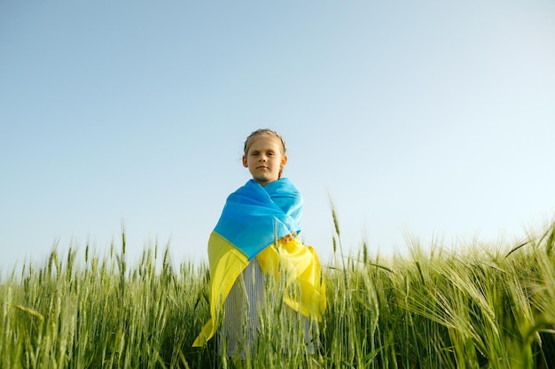 Menina com bandeira ucraniana no campo de trigo Menino feliz comemorando o dia da independência