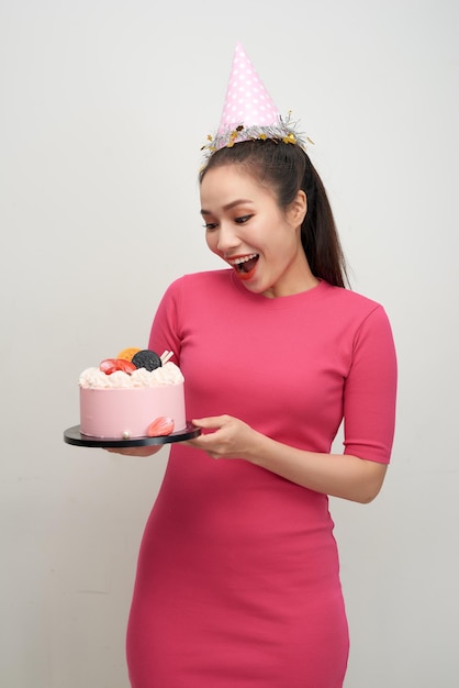 Menina com bolo de aniversário em um fundo branco