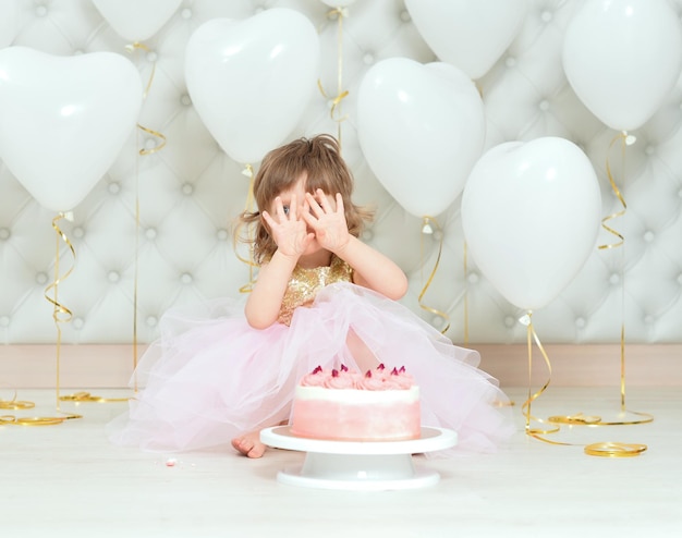 Menina com bolo em seu aniversário posando em casa