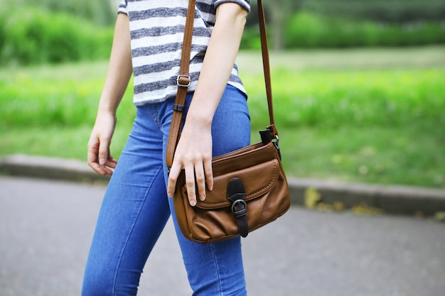 Menina com bolsa pendurada no ombro ao ar livre