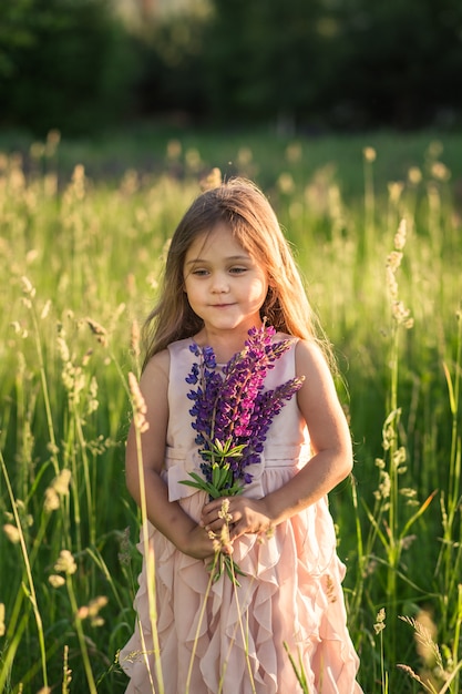 menina com cabelo comprido em um lindo vestido sobre a natureza no verão