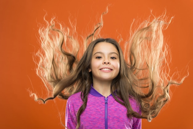 Menina com cabelo comprido. Ensinar hábitos saudáveis de cuidados com os cabelos à criança. Conceito de cabelo forte. Cabelo brilhante longa e saudável de garota garoto. O principal é mantê-lo limpo. Use shampoo suave e água morna.
