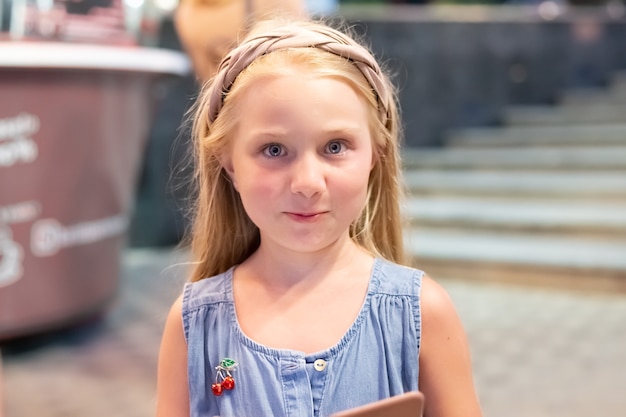 Menina com cabelo comprido loiro com a emoção de surpresa. férias de verão divertidas na cidade.