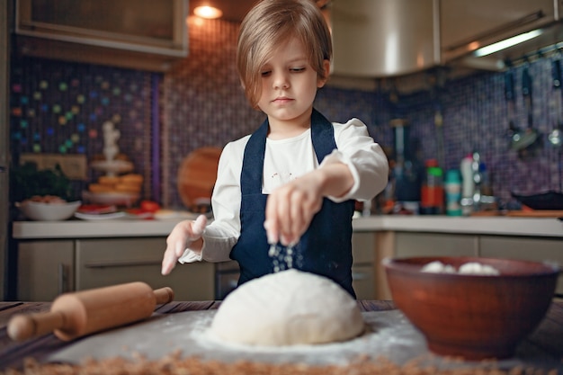 Menina com cabelo curto, amassar massa na cozinha