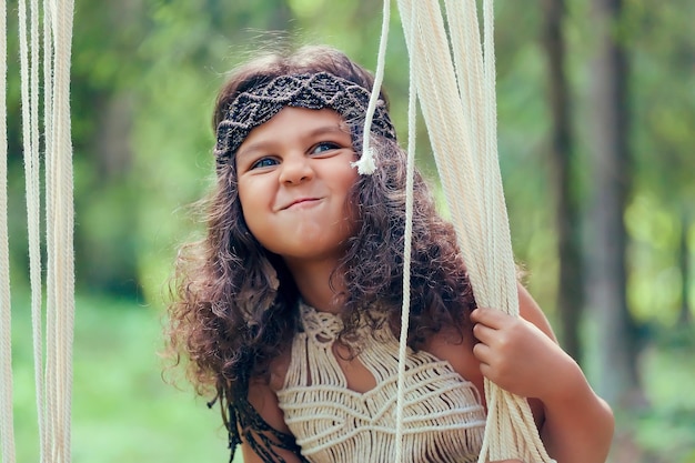 Menina com cabelo escuro encaracolado vestida como nativa da floresta