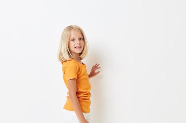 Menina com cabelo loiro em um fundo isolado de camiseta amarela