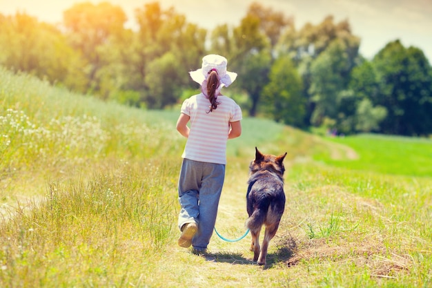 Menina com cachorro andando na estrada