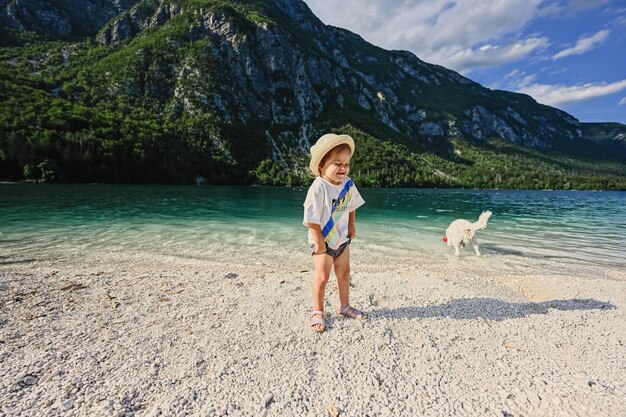 Menina com cachorro contra o Lago Bohinj, o maior lago da Eslovênia, parte do Parque Nacional de Triglav