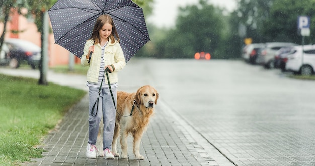 Menina com cachorro golden retriever em dia chuvoso