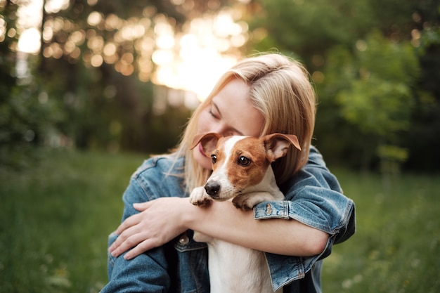 Menina com cachorro nas mãos, jack russell terrier