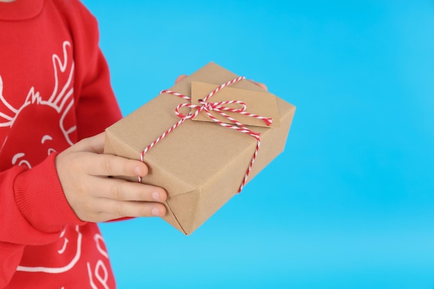 Menina com caixa de Natal em fundo azul