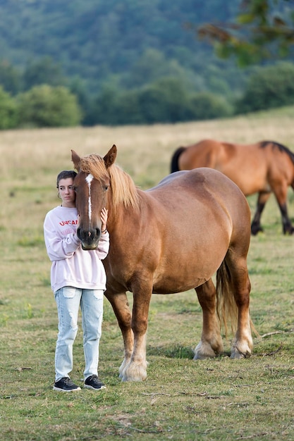 Foto menina com cavalo de pé no campo