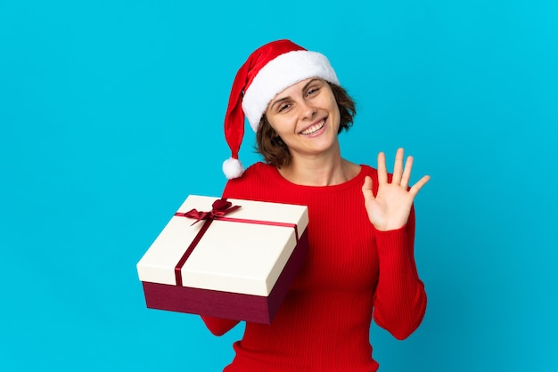 Menina com chapéu de Natal em um fundo azul