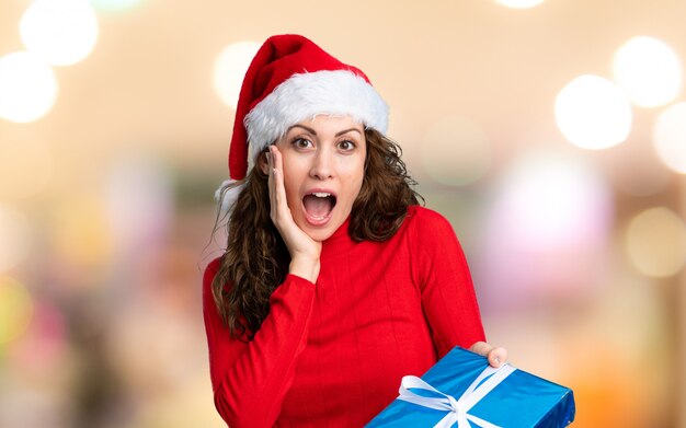 Menina com chapéu de natal na parede sem foco