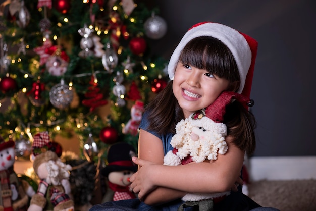 Menina com chapéu de papai noel na decoração de natal