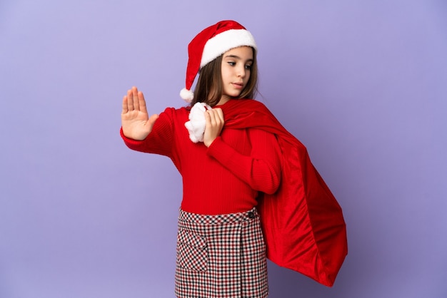 Menina com chapéu e saco de Natal isolado