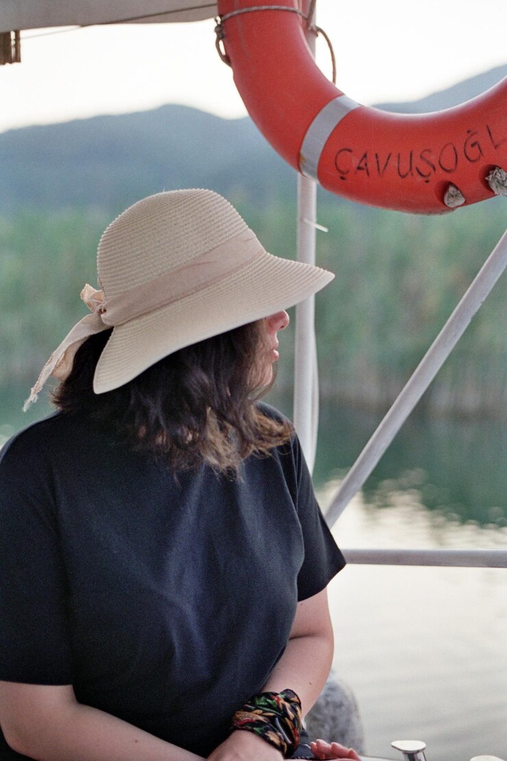 Foto menina com chapéu no barco