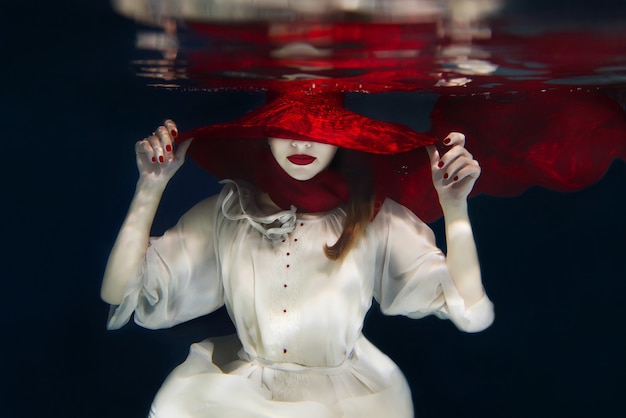 Menina com chapéu vermelho debaixo d'água