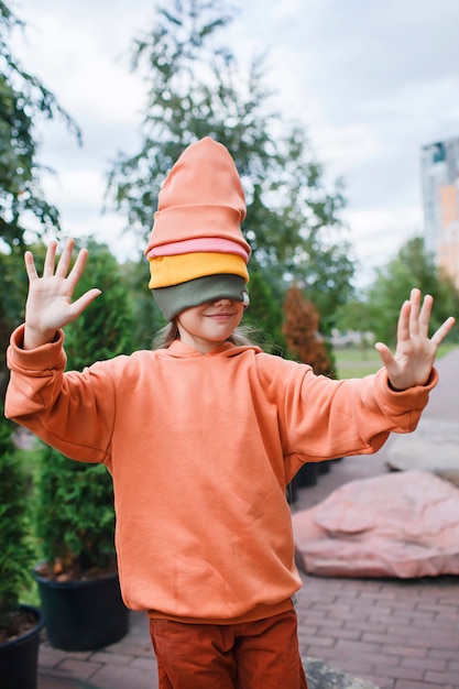 Menina com chapéus da moda e moletom se divertindo no parque outono vibrações outono beleza estilo infantil moda