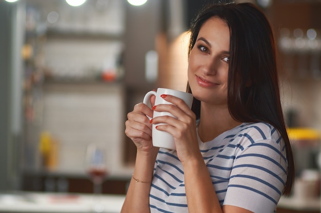 Menina com copo branco nas mãos