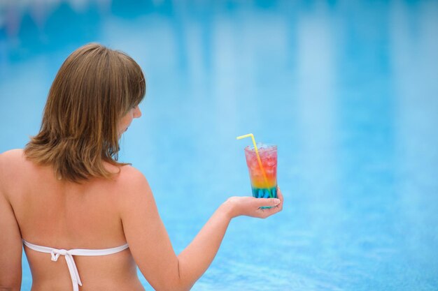 Foto menina com coquetel na piscina