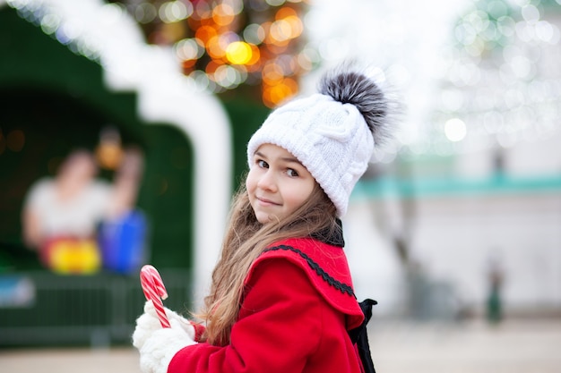 Menina com doces de Natal ao ar livre