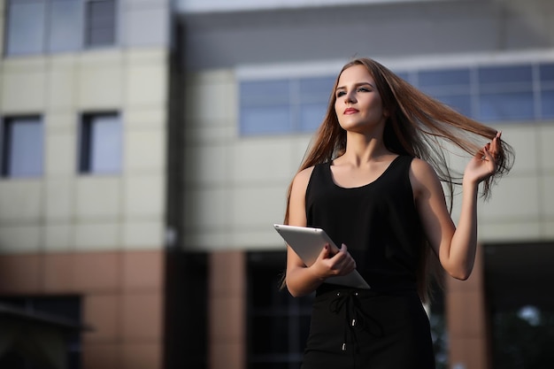 Menina com documentos em uma reunião de negócios perto de um edifício moderno