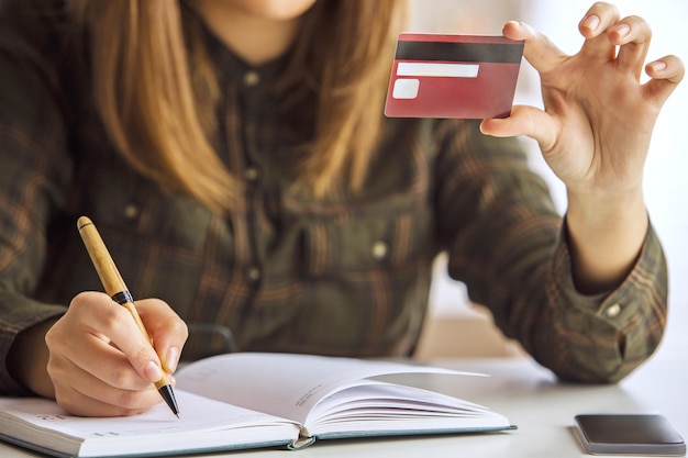 Menina com escrita de cartão de crédito