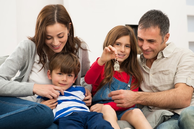 Menina com família mostrando a chave da casa