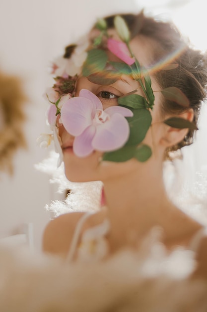 Menina com flores no rosto Foto artística de uma orquídea feminina no rosto