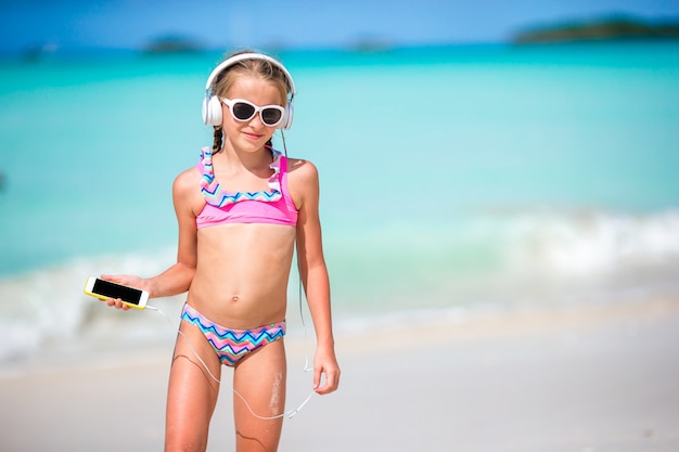 Menina com fones de ouvido na praia