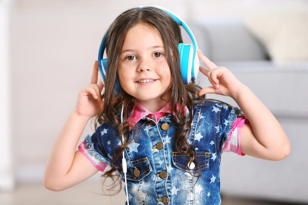 Menina com fones de ouvido na sala de perto