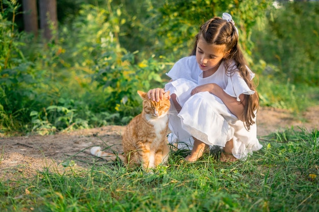 Menina com gato ruivo. belo retrato de menina com gato ruivo nas mãos.