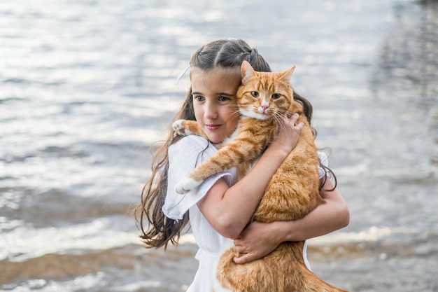 Menina com gato ruivo. Belo retrato de menina com gato ruivo nas mãos.