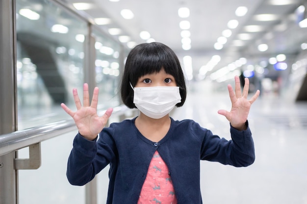 Menina com gripe de proteção facial de máscara cirúrgica e surto de vírus no transporte público