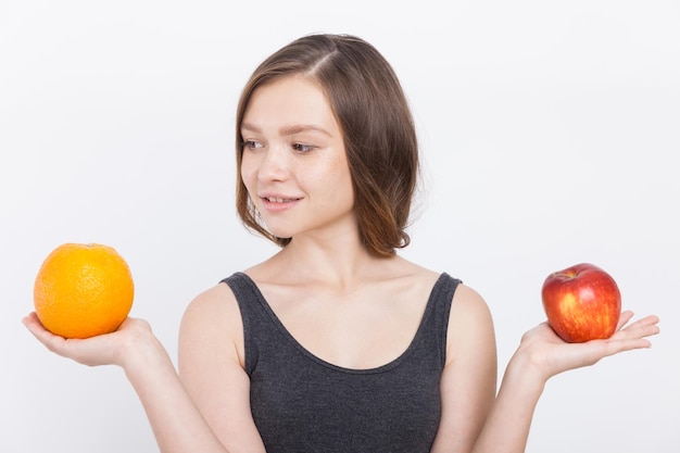 Menina com laranja e maçã