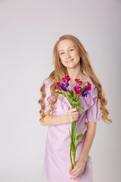 Menina com lindas flores em roupas roxas