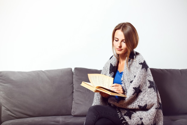 Menina com livro no sofá